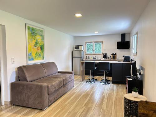 a living room with a couch and a kitchen at Les Bambous in Poissy