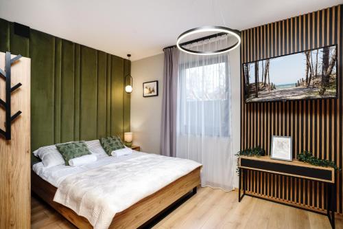 a bedroom with a large bed and a window at Apartamenty i Pokoje Złote Piaski in Jastrzębia Góra