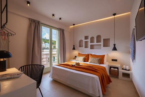 a bedroom with a bed and a desk and a window at Sugarwhite Suites with Private not Heated Pool in Emporio Santorini