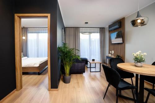 加茨比亚格拉Apartamenty i Pokoje Złote Piaski的一间带餐桌的客厅和一间卧室