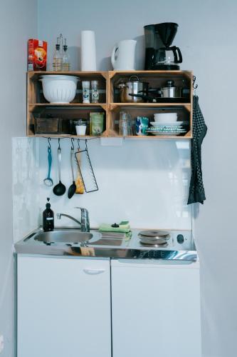 a kitchen with a sink and wooden shelves at Mountain View Salzburg - SELF CHECK-IN - Apartments in Grödig