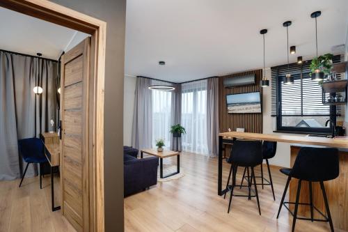 a kitchen and living room with a table and chairs at Apartamenty i Pokoje Złote Piaski in Jastrzębia Góra