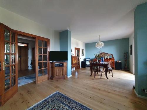 uma sala de estar com uma mesa de jantar e uma televisão em Casa di Laura in Chianti - large & charming house (host 7 people) em Moncioni