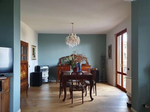 ein Esszimmer mit einem Tisch und einem Kronleuchter in der Unterkunft Casa di Laura in Chianti - large & charming house (host 7 people) in Moncioni