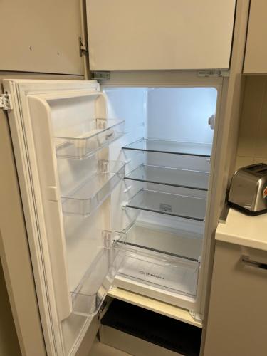 an empty refrigerator with its door open in a kitchen at Travelounge Milano San Siro in Milan