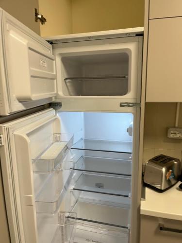 an empty refrigerator with its door open in a kitchen at Travelounge Milano San Siro in Milan