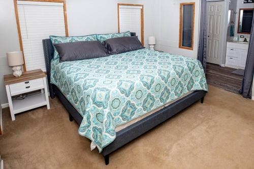 um quarto com uma cama com um edredão azul e branco em Home away from Home at Beyonder Getaway SH em Ankeny
