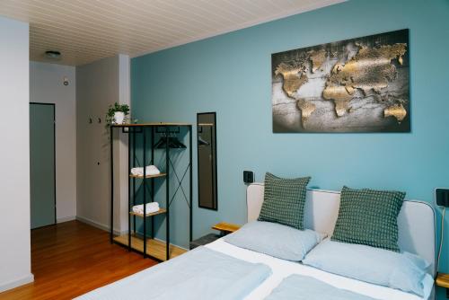 a bedroom with a white bed and a blue wall at Mountain View Salzburg - SELF CHECK-IN - Apartments in Grödig