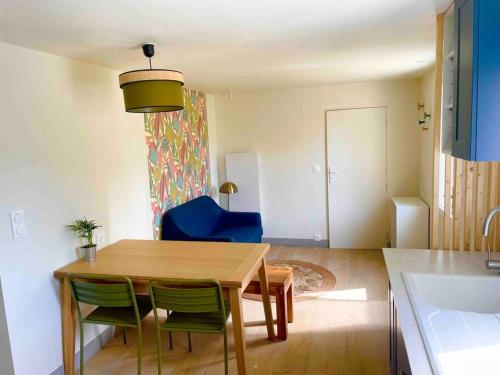uma sala de estar com uma mesa e uma cadeira azul em Petite maison avec jardin au calme em Floirac