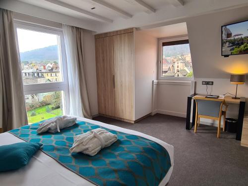 a bedroom with a bed with two towels on it at Best Western Plus Hotel & SPA Le Schoenenbourg in Riquewihr