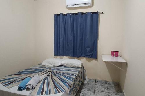 ein Schlafzimmer mit einem Bett mit einem blauen Vorhang in der Unterkunft Casa para Família in Porto Seguro