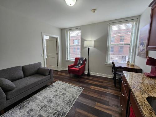 a living room with a couch and a red chair at One Bedroom Partment at the Inman - 202 in Champaign