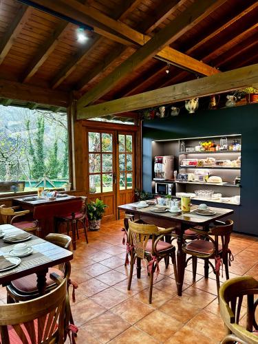 a restaurant with tables and chairs in a room at Apartamentos Rurales L'Arquera in Llanes