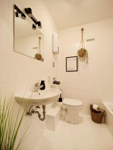 a white bathroom with a sink and a toilet at Stilvolle Designer Wohnung im Herzen der Altstadt in Wittlich