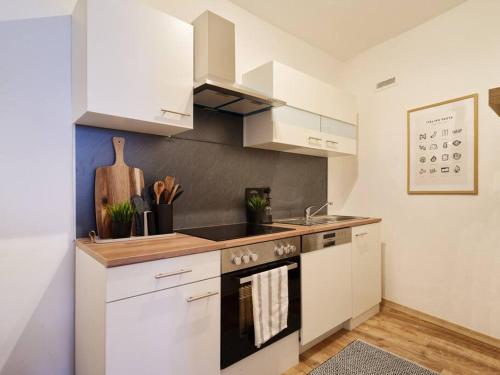 a kitchen with white cabinets and a stove top oven at Stilvolle Designer Wohnung im Herzen der Altstadt in Wittlich