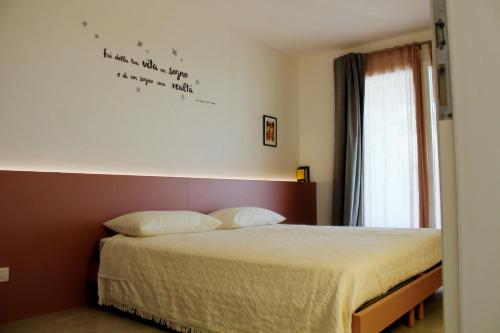 Dormitorio con cama con escrito en la pared en A CASA MIA b&b, en Cavaion Veronese