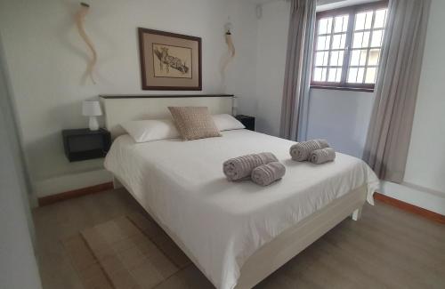 1 dormitorio con 1 cama blanca y 2 toallas en Onduno Self-catering en Swakopmund