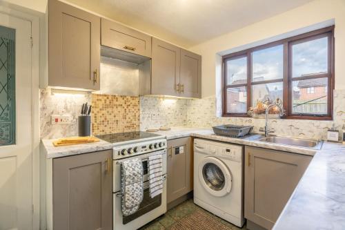 a kitchen with a sink and a washing machine at Spacious 5 rooms 6 beds in Banbury with Free Parking in Banbury
