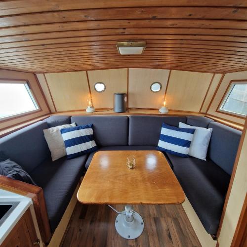 a couch with a table in the back of a boat at City Sailing in Amsterdam