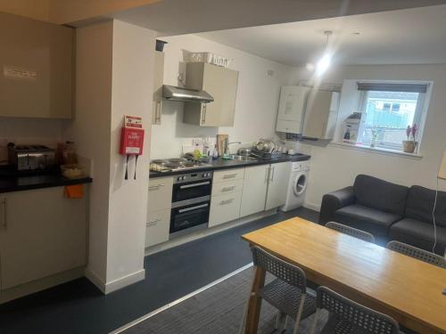 a kitchen and living room with a couch and a table at Stay Inn East West in Aberdeen