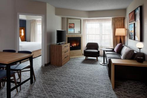 un salon avec un canapé et une chambre avec un lit dans l'établissement Residence Inn by Marriott Mississauga-Airport Corporate Centre West, à Mississauga