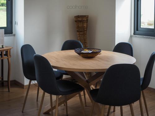 una mesa de madera con sillas y un bol en la parte superior en 12 Casa d'Avó, en Albergaria-a-Velha