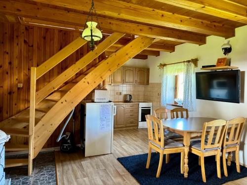 una cucina e una sala da pranzo con una scala in legno in una casa di Ubytování u hrádečku a Prostřední Bečva
