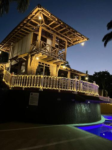 a wooden house with a balcony and a pool at Hotel campestre los Arrieros in Guaduas