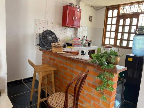 Hermoso apartamento, acogedor. في Mompós: مطبخ مع منضدة من الطوب مع كرسيين