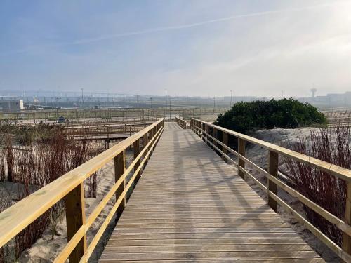 a wooden boardwalk over a beach with a view at GARDEN & BEACH HOUSE in Figueira da Foz