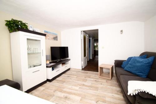 a living room with a couch and a flat screen tv at Villa Margarete in Sassnitz