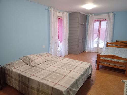 Schlafzimmer mit einem Bett, einem Stuhl und Fenstern in der Unterkunft La Bergerie de Lavernhe in Connac