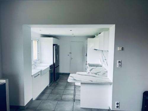ein weißes Bad mit einem Waschbecken und einem WC in der Unterkunft La villa des retrouvailles in Ploufragan