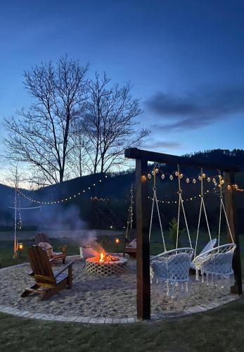 a fire pit with chairs and a tent and afire at Kinder Valley Morlaca Cluj in Bologa