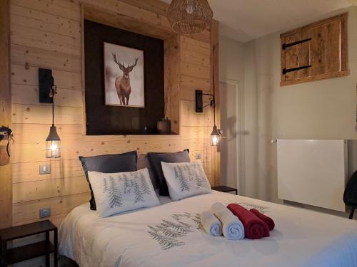 a bedroom with a bed with two towels on it at La Pause Ô Logis in Saint-Laurent-du-Jura