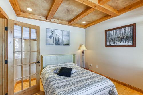 a bedroom with a bed with a lamp and a window at Hot Tub and Golf Course Views Luxe Sturgis Home! in Sturgis