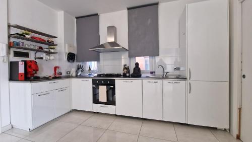 a white kitchen with white cabinets and a stove at LG colosseum Rome apartment in Rome