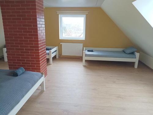 a attic room with two beds and a window at CozyStay in Otepää