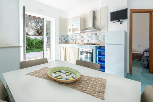 une cuisine blanche avec une table avec une assiette dessus dans l'établissement Casa Vacanze Villa Anna, à Palinuro