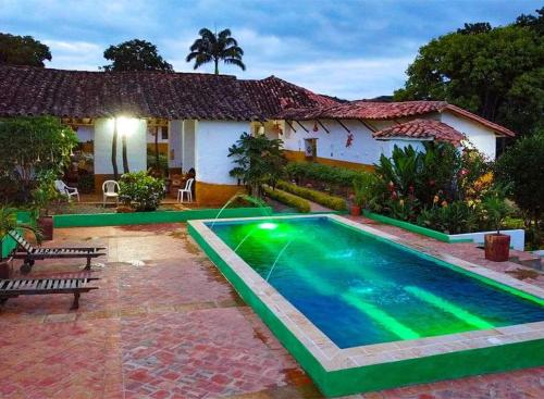 una casa con una piscina di fronte di HOSPEDAJE CASA GRANDE ARBOLITO a Barichara