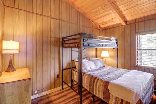 a bedroom with a bunk bed in a wooden wall at Rustic Waterfront Getaway on Greers Ferry Lake! in Fairfield Bay