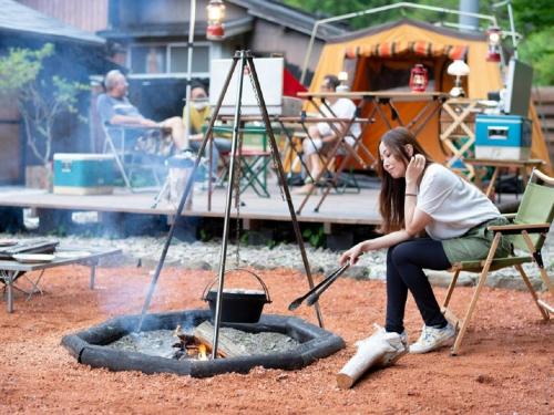 a woman sitting in a chair next to a fire at Camp-style inn Yamagara - Vacation STAY 41883v in Iwai