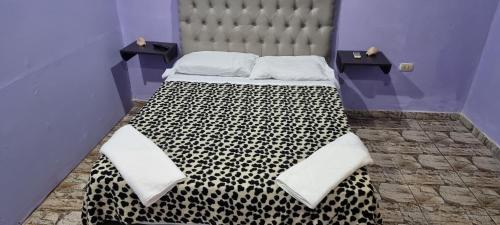 a bed with a black and white checkered bedspread at El Toro in San Fernando del Valle de Catamarca