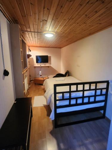 1 dormitorio con 1 cama y TV en Room At The Backyard In A Family House & Room Inside A Family House, 