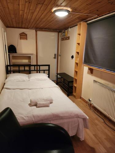 ein Schlafzimmer mit einem großen Bett und einer Leinwand in der Unterkunft Room At The Backyard In A Family House & Room Inside A Family House 