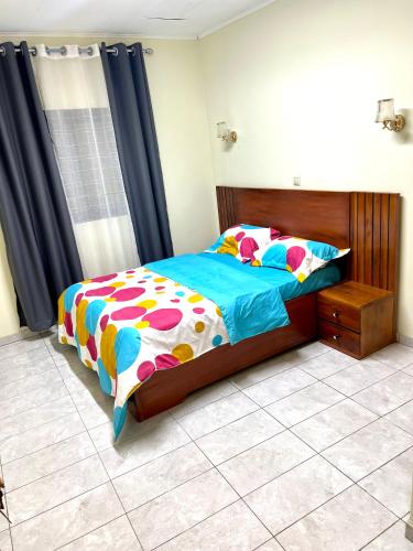 a bedroom with a bed with a colorful comforter at Hacienda Residence - Solar Energized in Yaoundé