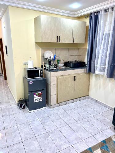 a small kitchen with a stove and cabinets at Hacienda Residence - Solar Energized in Yaoundé