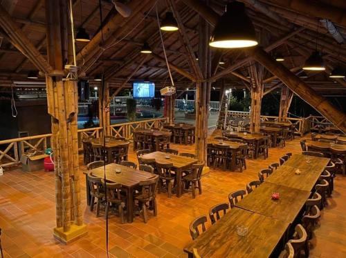 an empty restaurant with wooden tables and chairs at Hotel campestre los Arrieros in Guaduas