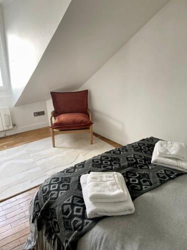 une chambre avec un lit et une chaise rouge dans l'établissement Charmant appartement parisien, à Paris