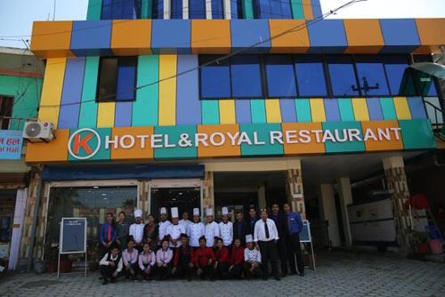 een groep mensen die voor een hotel en een koninklijk restaurant staan bij Khanal Hotel in Nepalgunj